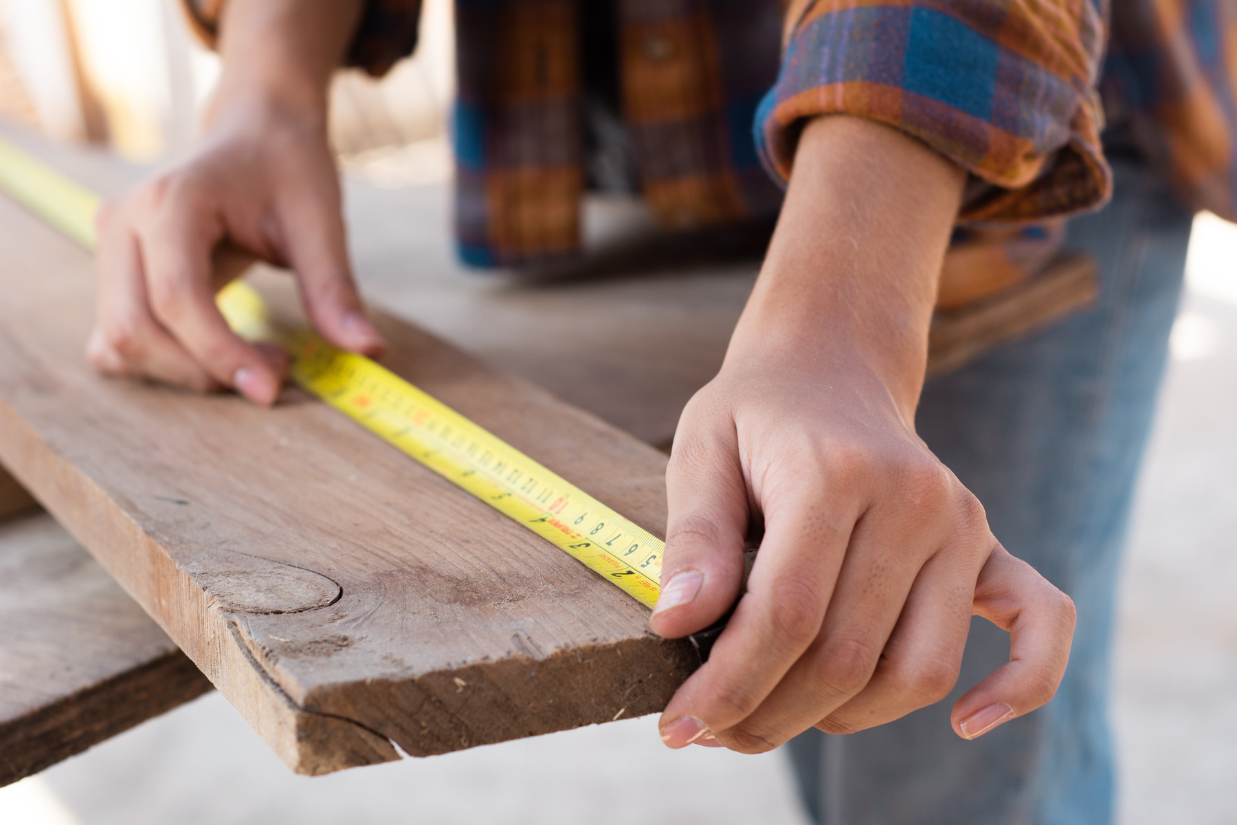 Close-Up Shot of a Carpenter Measuring a Wood Plank